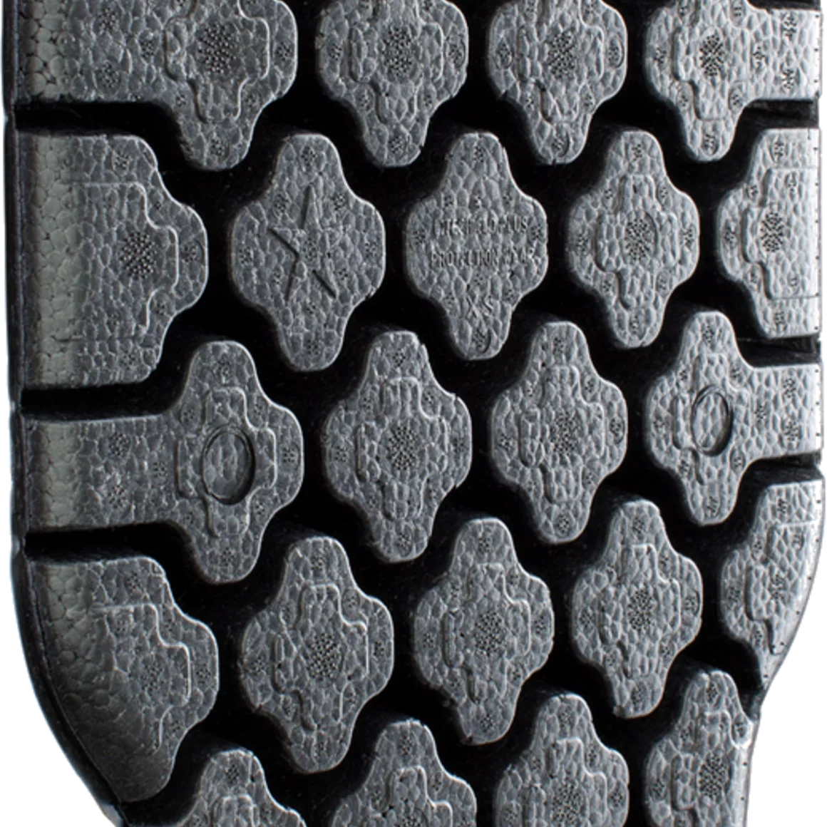Close-up of a textured rubber sole with a repeating geometric pattern. © EVOC Sports GmbH