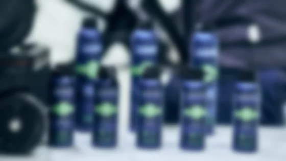 Mehrere dunkelblaue Spraydosen von TUNAP SPORTS für Fahrräder stehen auf einer hellen Fläche. Die Dosen sind mit einem grünen Etikett versehen, auf dem ein Fahrrad abgebildet ist und die jeweilige Funktion des Produkts angegeben ist: Multifunktionsöl, Kettenöl und Kettenwachs. Die Vorderseite der Dosen zeigt den Markennamen TUNAP SPORTS und das Wort „FAHRRAD“. Die Produktbeschreibungen betonen Eigenschaften wie Langlebigkeit, Schmutz- und Wasserabweisung, sowie Schutz vor Verschleiß. Der Hintergrund ist unscharf und zeigt einen Teil einer dunklen Tasche oder eines Beutels. Das Bild vermittelt einen Eindruck von Sauberkeit, Funktionalität und hochwertigen Fahrradpflegeprodukten. © Sport Kessler GmbH