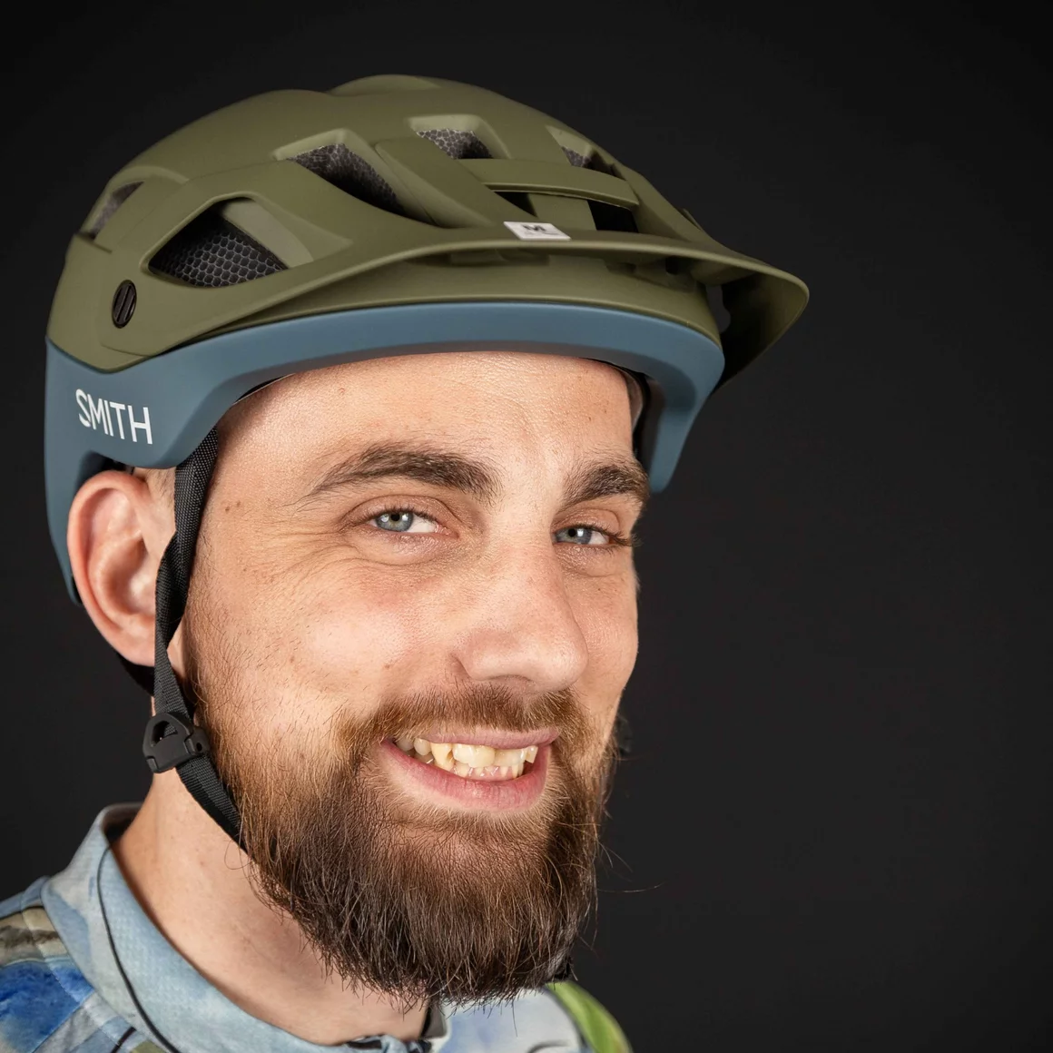 Mann mit Bart trägt grünen Fahrradhelm vor schwarzem Hintergrund © Sport Kessler GmbH