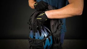 Mann verstauert einen Fahrradhelm in einem Rucksack. © Sport Kessler GmbH