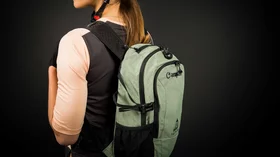 Frau mit Helm und salbeigrünem Campin-Rucksack. © Sport Kessler GmbH