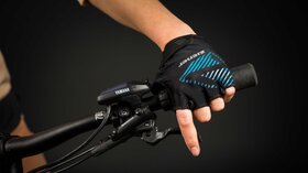 Close-up of a hand wearing a cycling glove gripping the handlebars of an electric bicycle. © Sport Kessler GmbH