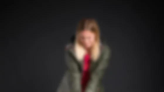 Studioaufnahme: Junge Frau in olivgrüner Jacke und rosa Hose mit Plüschhund. © Sport Kessler GmbH