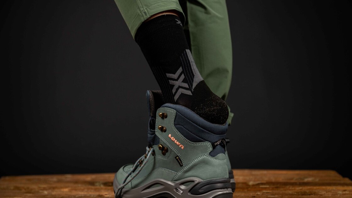 Lowa Wanderschuhe an einem Holztisch. © Sport Kessler GmbH