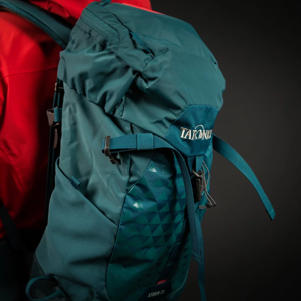 Tatonka Storm 20 Rucksack auf roter Jacke. © Sport Kessler GmbH