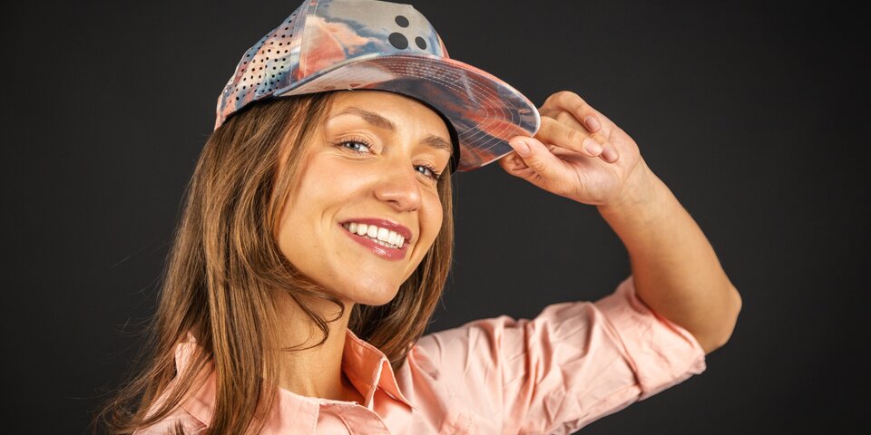 Lächelnde junge Frau mit Baseballkappe. &copy; Sport Kessler GmbH