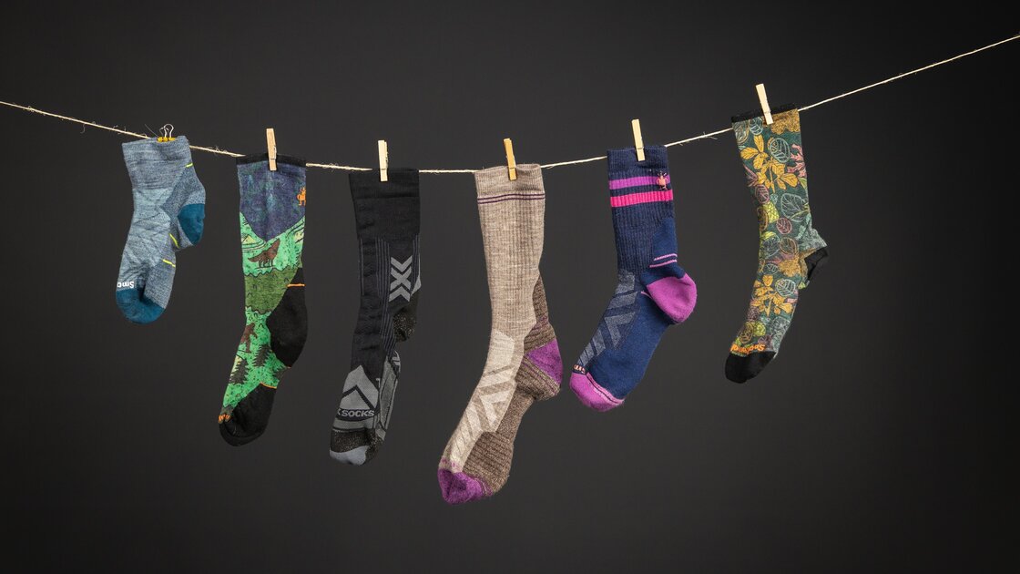 Six colorful socks hanging on a clothesline against a dark background. &copy; Sport Kessler GmbH