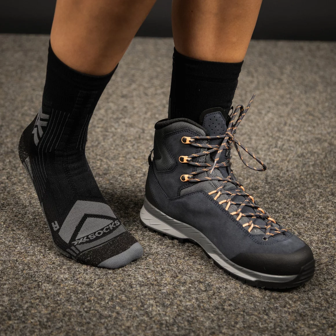 Wandererfüße in schwarzen Socken und dunkelblauen Wanderschuhen. © Sport Kessler GmbH