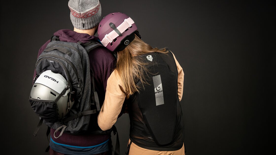 Couple in winter sports gear standing back to camera. © Sport Kessler GmbH