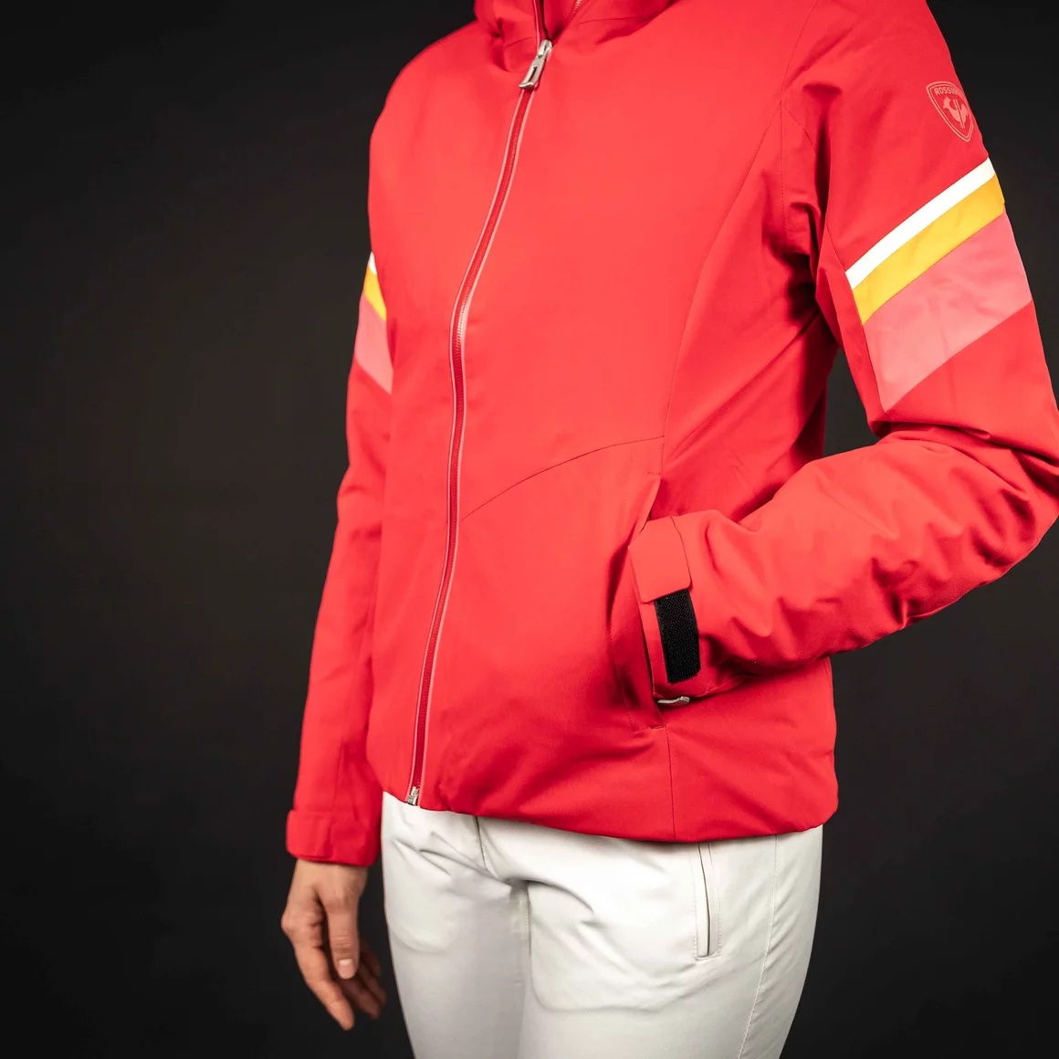 Red ski jacket with white and yellow stripes on the sleeve. © Sport Kessler GmbH