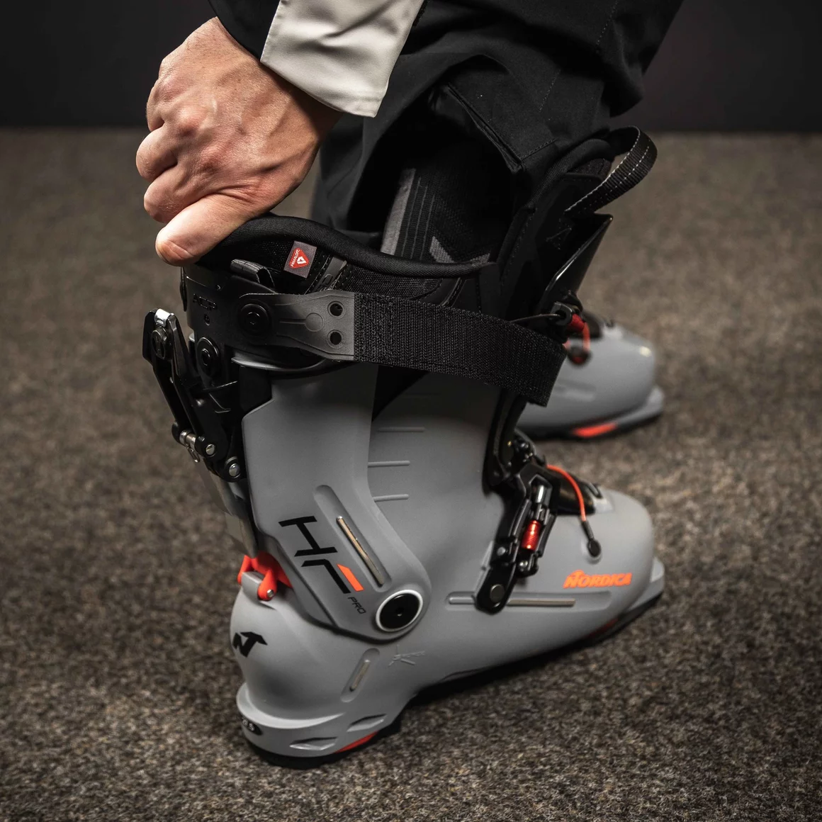 Person adjusting a gray and black ski boot. © Sport Kessler GmbH
