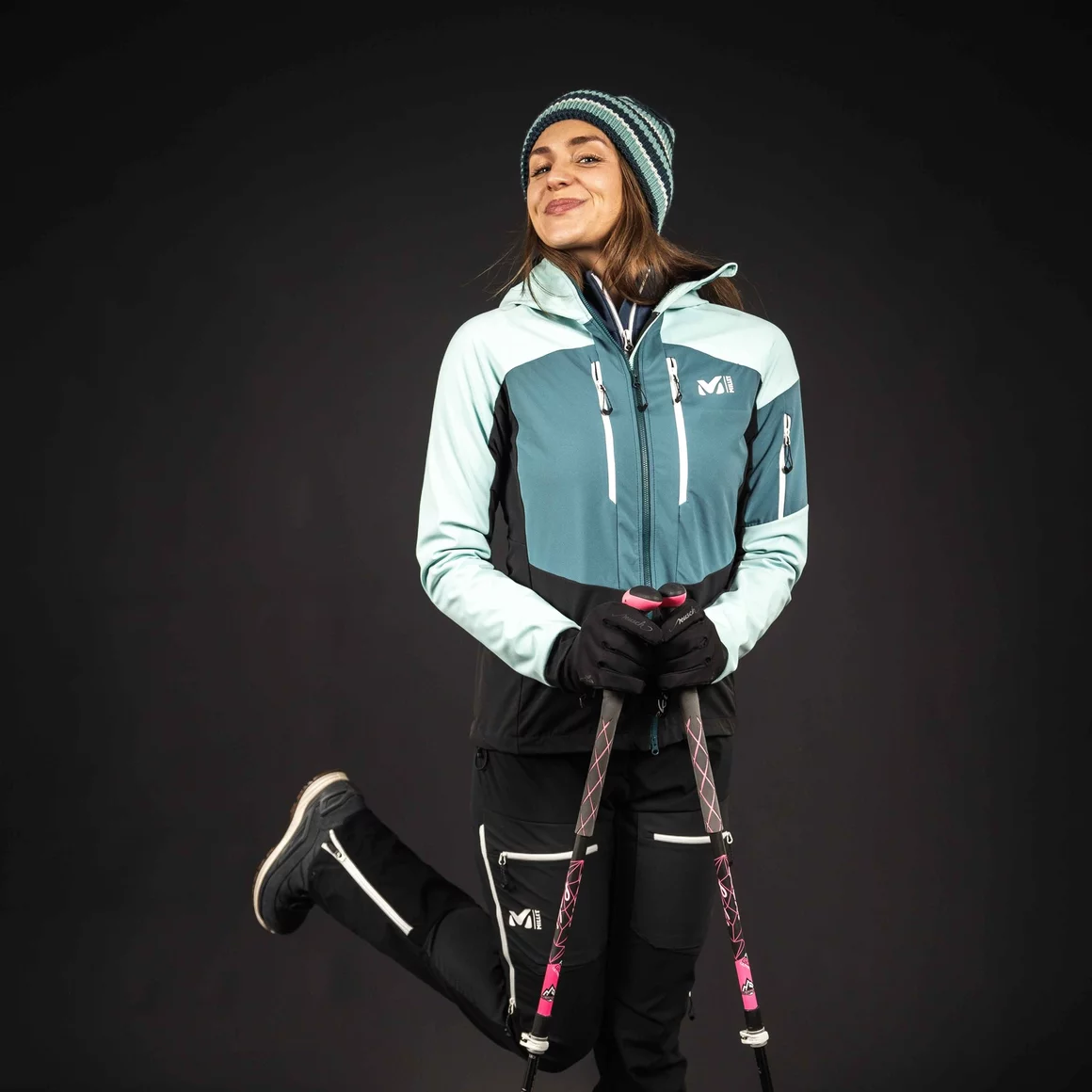 Woman in ski outfit holding ski poles © Sport Kessler GmbH