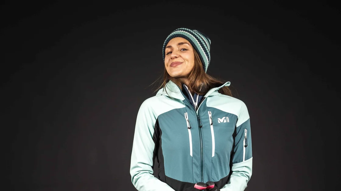 Woman in ski outfit holding ski poles © Sport Kessler GmbH