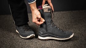 Person zieht dunkelgrauen Winterstiefel an. © Sport Kessler GmbH