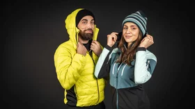 Mann und Frau in Winterkleidung vor dunklem Hintergrund. © Sport Kessler GmbH