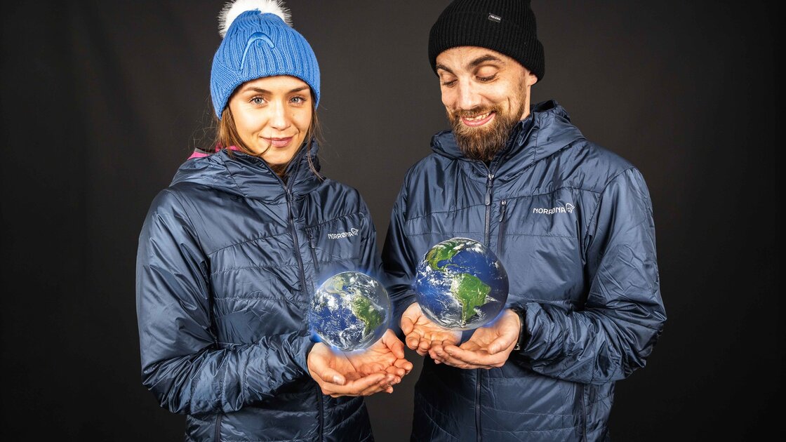 Zwei Personen in blauen Outdoor-Jacken halten leuchtende Hologramm-Erden in ihren Händen. © Sport Kessler GmbH