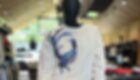 Mannequin in a cream sweatshirt with a blue bird graphic and denim jeans. © Sport Kessler GmbH