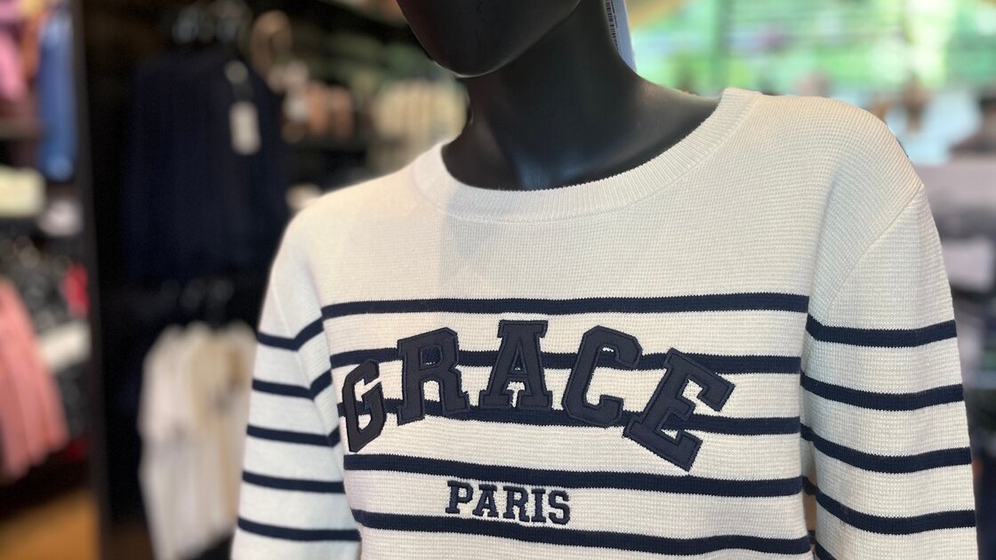 Mannequin displaying a white and navy striped sweater with 