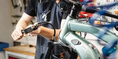 Mechaniker repariert eine grüne E-Bike-Gabel. © Sport Kessler GmbH