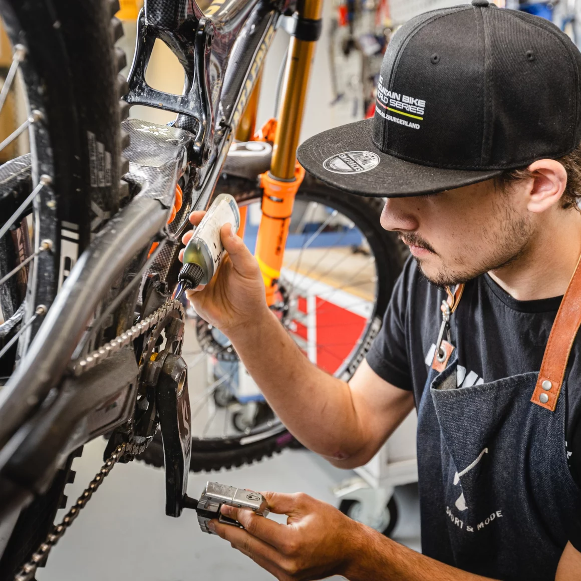 Mechanic lubricating a mountain bike chain. © Sport Kessler GmbH