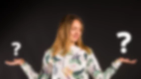Woman contemplating two options, symbolized by question marks. © Sport Kessler GmbH