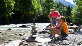 Eltern und Kinder spielen am Fluss in den Bergen © Sport Kessler GmbH