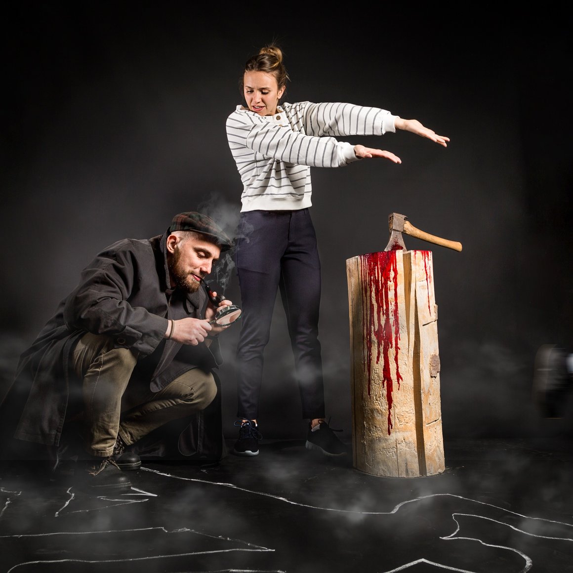 A detective and a woman investigate a crime scene with a bloody axe. © Sport Kessler GmbH